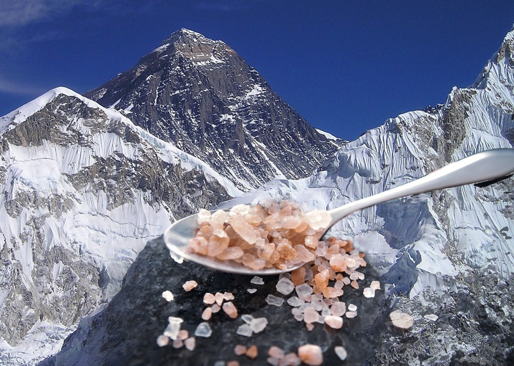 Das Bild zeigt einen Löffel mit pinkem Salz. Im Hintergrund ist der Mount Everest zu sehen.